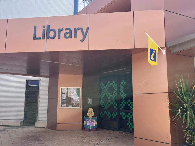 Entrance showing blue and yellow information sign and green crosses on auto door